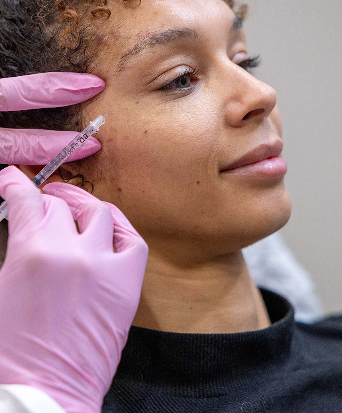 Administering cosmetic injection to a patient.