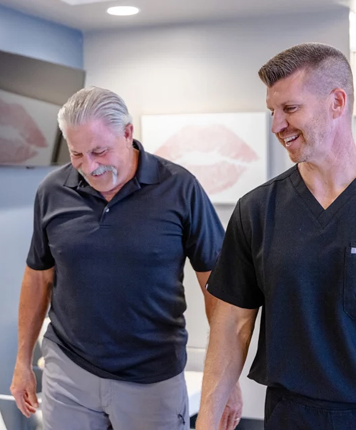 Two men smiling in a professional setting.