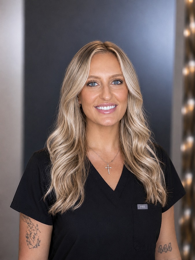 Maya smiling woman in black scrubs portrait.