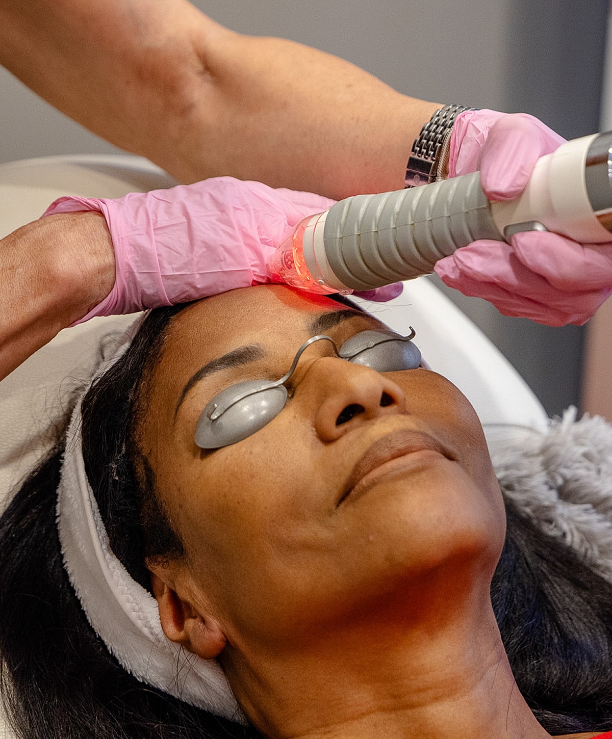 Facial treatment with laser therapy in progress.