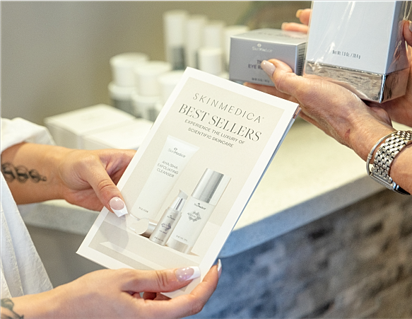 Person holding skincare product brochure in store.
