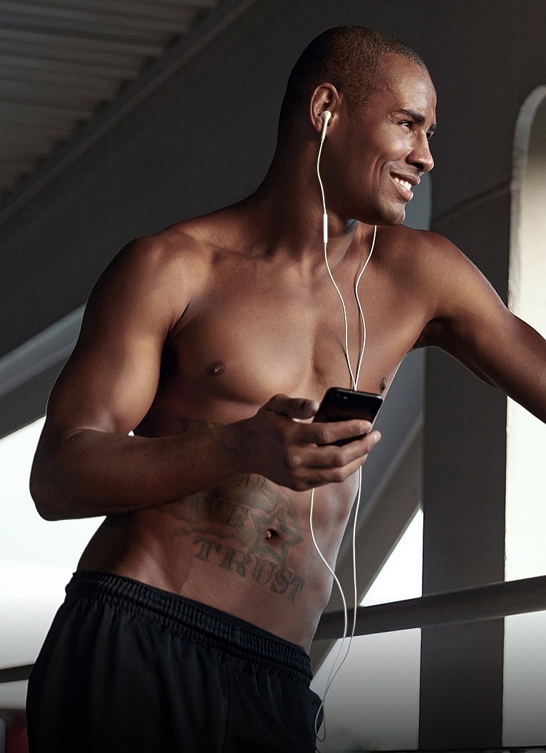 Man listening to music while holding a smartphone.