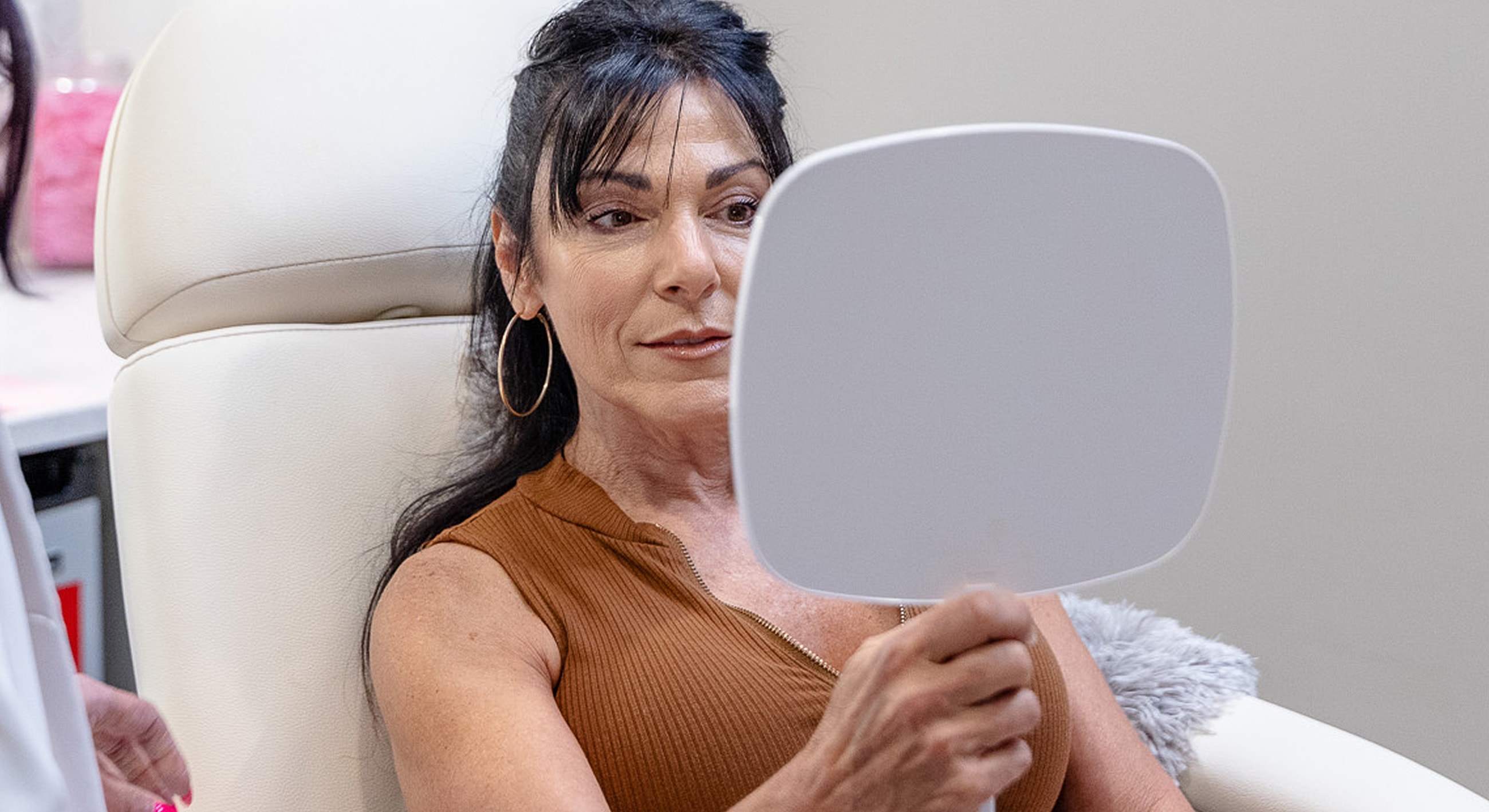 Woman examining her reflection in a mirror.