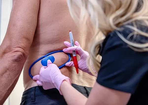 Medical professional examining a patient's back.
